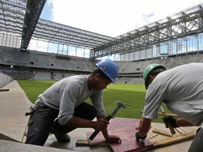 Oper&aacute;rios trabalham nas obras da Arena da Baixada.