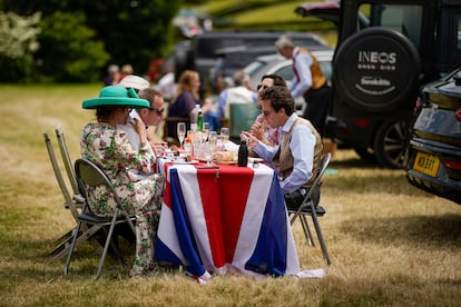 Un grupo de asistentes disfruta de un almuerzo sobre la bandera de Inglaterra durante el primer día de Ascot.