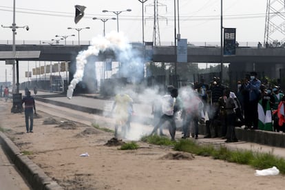 Los manifestantes lanzan botes de gas lacrimógeno lanzados por la policía este sábado en Lagos.