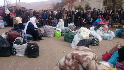 Un grupo de sirios espera la llegada de un convoy de ayuda humanitaria en Madaya.