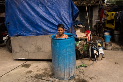 Un niño se remoja en un barril en Nueva Delhi.