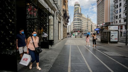 Varias personas salen de una tienda de moda en la Gran Vía, Madrid.