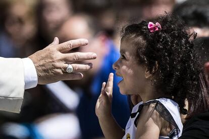 El papa Francisco saluda a una niña en su camino hacia la plaza de San Pedro del Vaticano para presidir la audiencia general de los miércoles.
