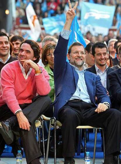 Rajoy saluda con la señal de la victoria junto a Aznar en el mitin de León.