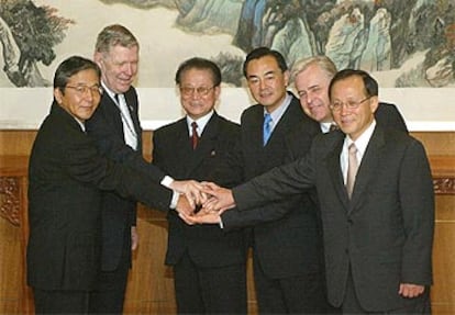 Los jefes de las delegaciones de las dos Coreas, EE UU, China, Japón y Rusia, chocan las manos en el Palacio de Diaoyutai de Pekín.