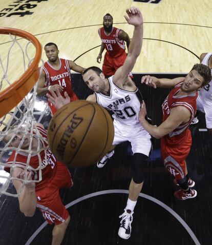 Cole Aldrich y Daequan Cook, de los Rockets, desequilibran a Manu Ginobili en su entrada a canasta.