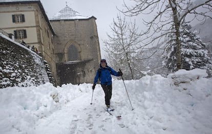 Una persona camina con sus esquíes por los alrededores de la Colegiata de Roncesvalles (Navarra), hoy.
