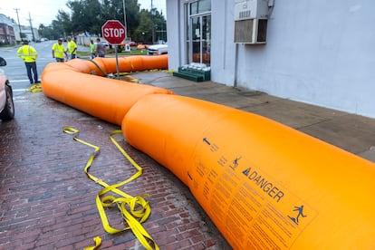  Workers place a flood protection barrier around the buildings as the town prepares for Hurricane Helene in Live Oak, Florida.