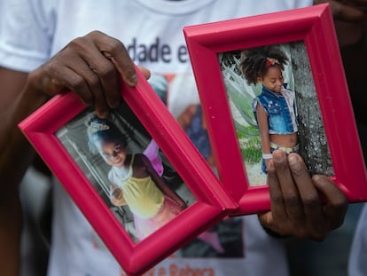 Ana Lúcia Silva Moreira, mãe de Emily Victória, 4, segura as fotos da filha e de sua sobrinha, Rebeca Beatriz, 7, mortas pela polícia.