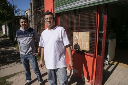 Luis Cáceres (dcha), junto a su hijo Yamil, frente al negocio de comidas familiar en Lomas de Zamora.