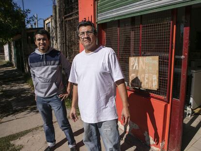 Luis Cáceres (dcha), junto a su hijo Yamil, frente al negocio de comidas familiar en Lomas de Zamora.