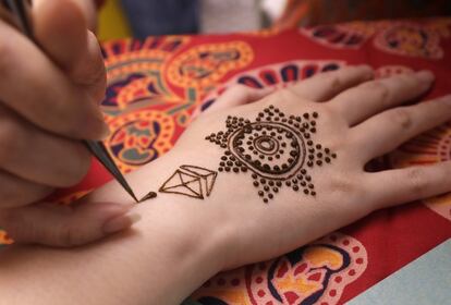 Una artista aplica henna en la mano de una mujer durante el festival hindú de las luces Diwali, en Taipei, Taiwán.