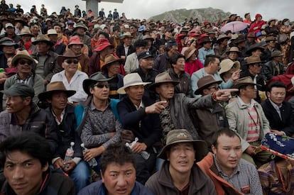 Espectadores tibetanos miran una carrera en la meseta del Tíbet, en el condado de Yushu (China).