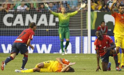 Puyol se duele en el suelo tras un choque con Lamah.