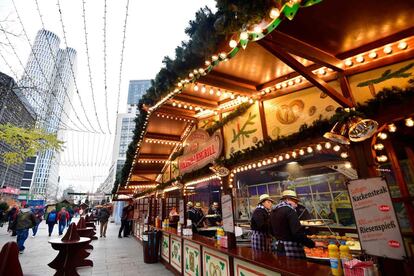 Vendedores se preparan para abrir sus puestos del mercado navideño al público en la plaza berlinesa de Breitscheidplatz.