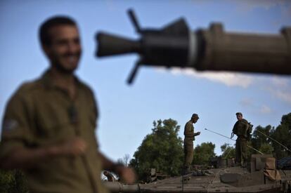 Soldados israelenses sobre um tanque na fronteira com Gaza.