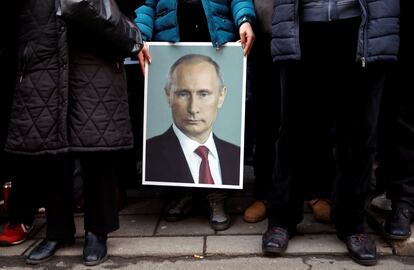 Un seguidor del presidente ruso, Vladímir Putin, muestra un cartel con su imagen, en Belgrado en enero de 2019.