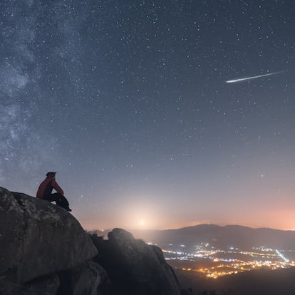A man watching a shoothing star, the the milky way and the moonset