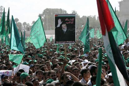 Supporters hold Hamas flags and then-Palestinian Authority Prime Minister Ismail Haniyeh's poster as Haniyeh speaks at a Hamas rally on October 6, 2006 in Gaza City. 