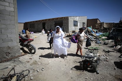 Uyuni, Bolivia, 2 de octubre de 2021: Paola, vestida de novia, camina usando la pierna ortopédica y con la ayuda de muletas. Tras el matrimonio civil en el Salar, los contrayentes celebraron una ceremonia religiosa en Uyuni, antes de concluir las celebraciones con una fiesta en la casa de la madre de Paola.