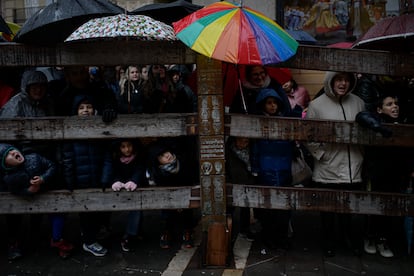 Decenas de personas se cubren bajo la lluvia mientras esperan la llegada de los Reyes Magos, este viernes, en Pamplona. 