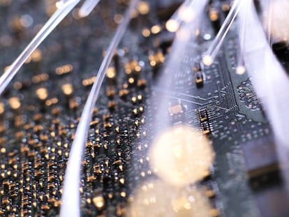 Detalle de la fibra óptica iluminada en la placa del circuito de un ordenador.