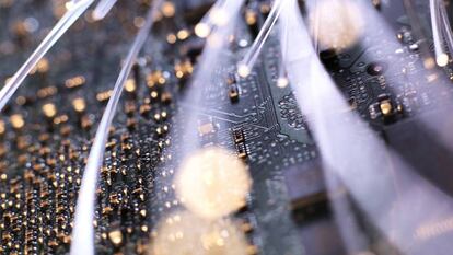 Detalle de la fibra óptica iluminada en la placa del circuito de un ordenador.