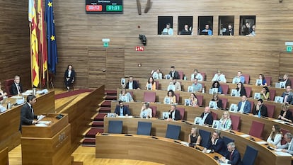 Los diputados socialistas muestran fotos del poeta Miguel Hernández durante la intervención del presidente de la Generalitat, Carlos Mazón.