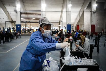 Una mujer reparte tapabocas en un centro de testeo contra la covid-19, este viernes 5 de junio en el Estadio de San Lorenzo, en la ciudad de Buenos Aires.