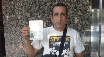 Rogelio Betancourt muestra su pasaporte en un caf&eacute; de la plaza de Castilla en Madrid, junio de 2014.