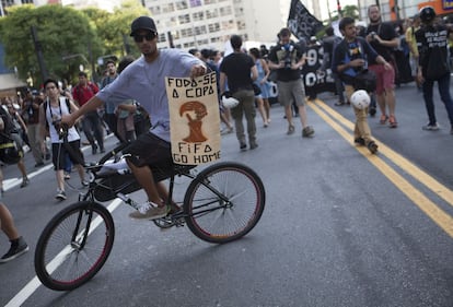 Manifestante segura um cartaz com mensagens contra a Copa do Mundo no Brasil, durante protesto em S&atilde;o Paulo.