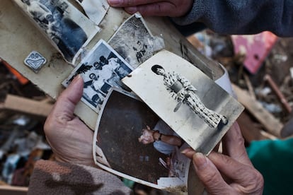 Una mujer muestra, en el álbum recuperado de los escombros, fotografías de varios familiares.