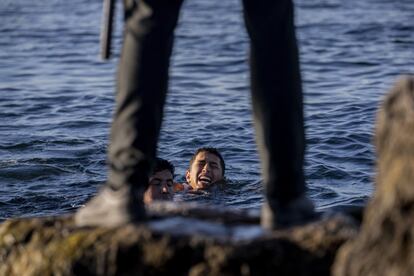 Un guardia civil espera la llegada de dos migrantes a la playa del Tarajal, en Ceuta, este miércoles. La Delegación del Gobierno en la ciudad autónoma ha elevado este miércoles por la mañana a 4.800 el número de personas que ya han sido devueltas a Marruecos o que han retornado voluntariamente tras acceder irregularmente a Ceuta entre la madrugada del lunes y la tarde de este martes, cuando las entradas, que se cifran en un total de 8.000, se han reducido a prácticamente cero.