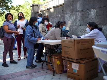 Decenas de personas acuden al reparto de alimentos de la Fundación Madrina en la plaza San Amaro, el pasado junio en Madrid.