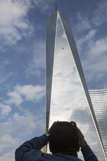 Un hombre observa desde abajo a los dos limpiacristales colgados en el World Trade Center