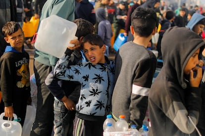 Palestinian children line up to collect drinking water in Rafah, southern Gaza Strip, on January 4, 2024.