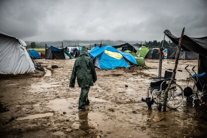 Un hombre camina por el campamento cubierto con un chubasquero repartido por Médicos Sin Fronteras. Las precarias condiciones del campo hacían la vida prácticamente imposible. (Mayo 2016)