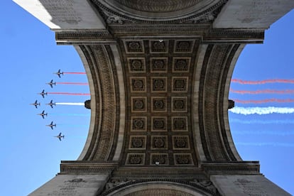 Aviones de la Patrouille de France liberan humo con los colores de la bandera nacional al sobrevolar el Arco del Triunfo durante un ensayo este lunes, tres días antes del desfile del Día de la Bastilla, fiesta nacional en Francia. 