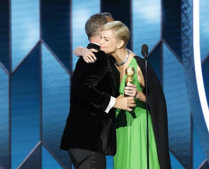 Charlize Theron abraza a Tom Hanks tras entregarle el premio.