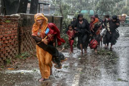 People move from their homes to take shelter in the nearest cyclone shelter at Shah Porir Dwip during the landfall of cyclone Mocha in Teknaf, Bangladesh, May 14, 2023.