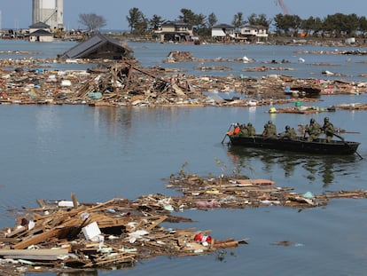 Self-Defense Force officers search for missing people by a boat after a tsunami and earthquake in Souma City in Fukushima Prefecture March 12, 2011. Japan confronted devastation along its northeastern coast on Saturday, with fires raging and parts of some cities under water after a massive earthquake and tsunami that likely killed at least 1,000 people. REUTERS/Yomiuri  (JAPAN - Tags: DISASTER SOCIETY MILITARY) FOR EDITORIAL USE ONLY. NOT FOR SALE FOR MARKETING OR ADVERTISING CAMPAIGNS. JAPAN OUT. NO COMMERCIAL OR EDITORIAL SALES IN JAPAN