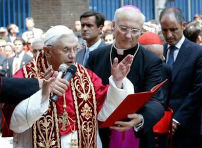 Benedicto XVI reza durante su visita a Valencia, en julio de 2006. A la derecha, Francisco Camps.