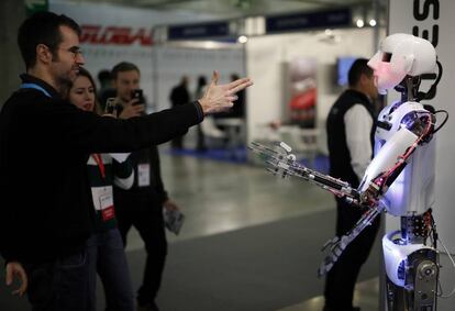 Un visitante interactúa con uno de los robots inteligentes de la feria.