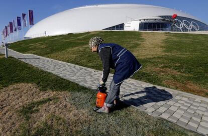 Un empleado pulveriza la hierba del exterior del palacio de hielo de Bolshoi en el Parque Olímpico de Sochi.