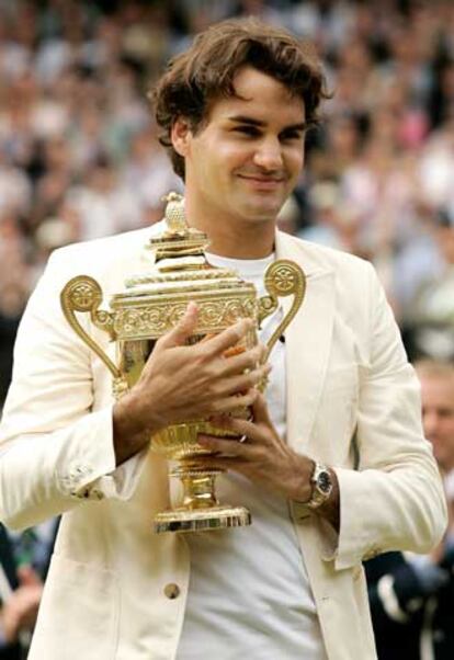 Roger Federer abraza la copa de campeón de Wimbledon.