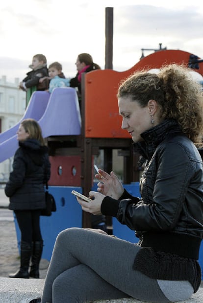Una mujer fuma en un parque infantil de Valencia.