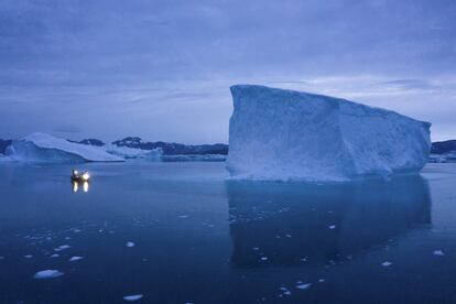 Um navio navega à noite com icebergs no leste da Groenlândia em 15 de agosto de 2019. O verão de 2019 está atingindo a ilha com calor recorde e derretimento extremo. Os cientistas estimam que até o final do verão cerca de 440 bilhões de toneladas de gelo, talvez mais, terão derretido ou se soltado da camada gigante de gelo da Groenlândia.