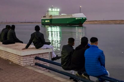 Un grupo de personas observa el paso  de un barco por el canal de Suez en su ruta hacia el mar Rojo el pasado noviembre.