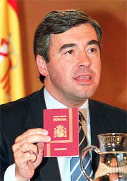 El ministro Ángel Acebes muestra el nuevo pasaporte.