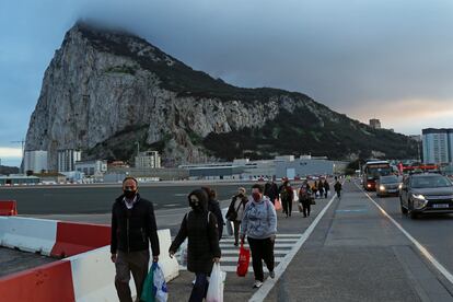 Peatones y vehículos cruzan la pista del aeropuerto de Gibraltar camino de la Verja para pasar a España.